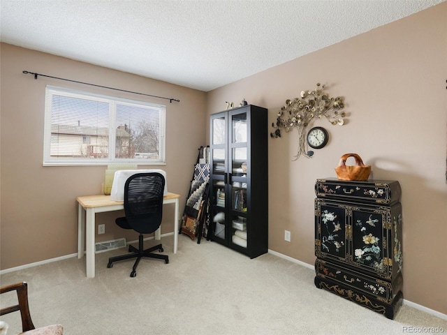 carpeted office space featuring visible vents, baseboards, and a textured ceiling