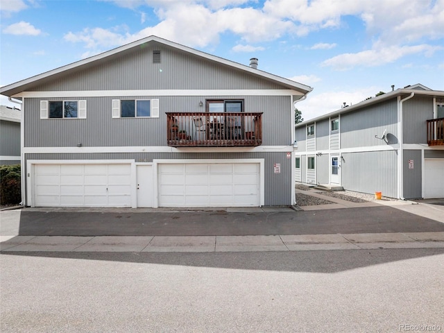 view of front facade with a garage and a balcony