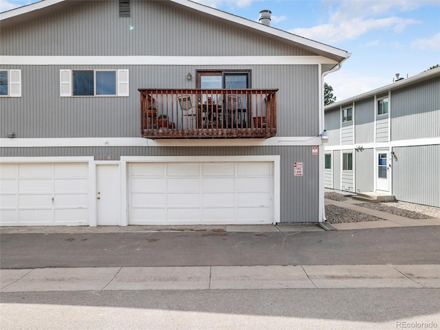 view of front of property featuring a garage and a balcony