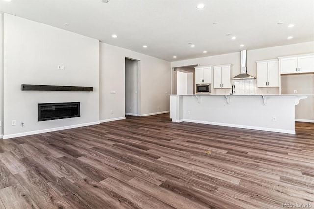 unfurnished living room featuring dark hardwood / wood-style flooring and sink