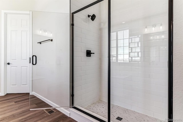 bathroom featuring hardwood / wood-style floors and walk in shower