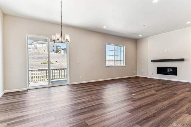 unfurnished living room with dark hardwood / wood-style flooring and an inviting chandelier