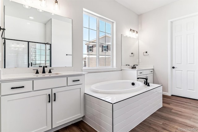 bathroom with vanity, wood-type flooring, and shower with separate bathtub