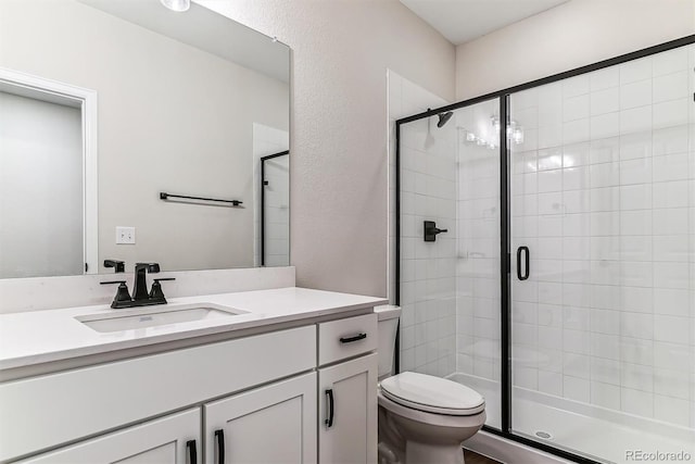 bathroom with vanity, an enclosed shower, and toilet