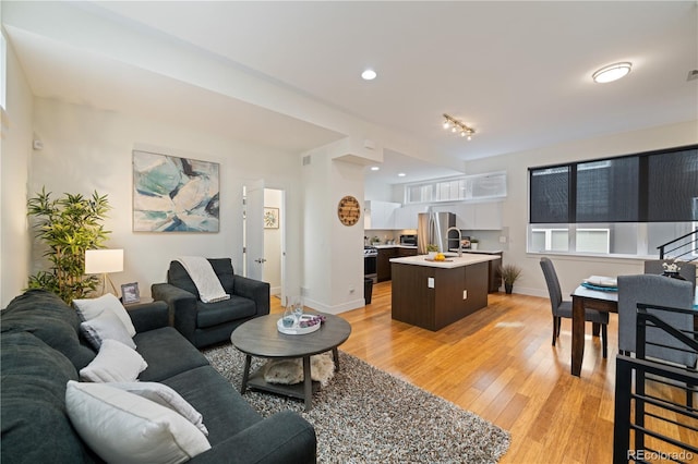 living room with light hardwood / wood-style flooring and sink