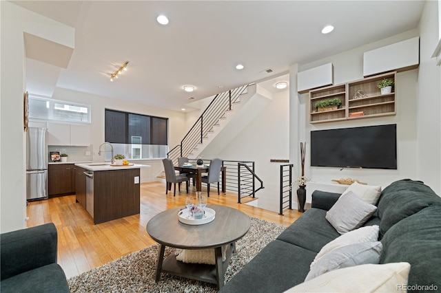 living room featuring light wood-type flooring and sink