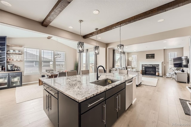 26731 E Hinsdale Pl, Aurora, CO 80016 - kitchen featuring light wood-style floors, a sink, beam ceiling, and a fireplace
