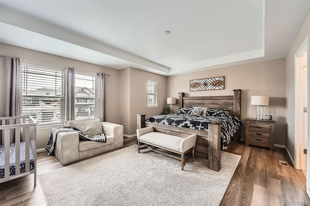 26731 E Hinsdale Pl, Aurora, CO 80016 - bedroom featuring baseboards, wood finished floors, and a tray ceiling