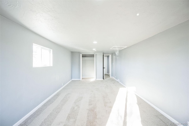 unfurnished bedroom with light carpet, a closet, recessed lighting, and baseboards