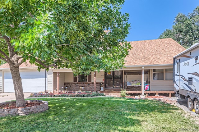 view of front of home with covered porch, a garage, and a front lawn