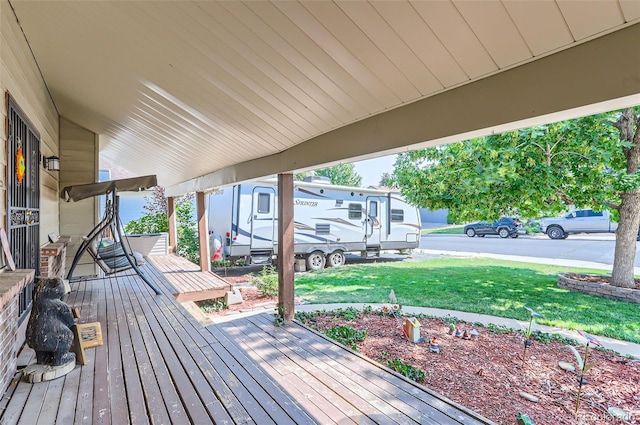 deck with a porch and a yard