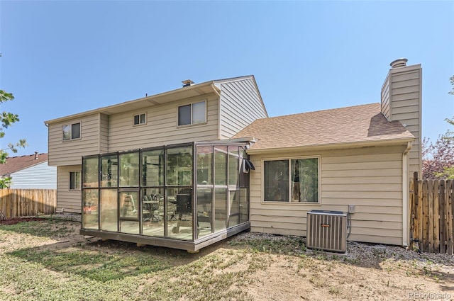 rear view of property with a sunroom and central AC