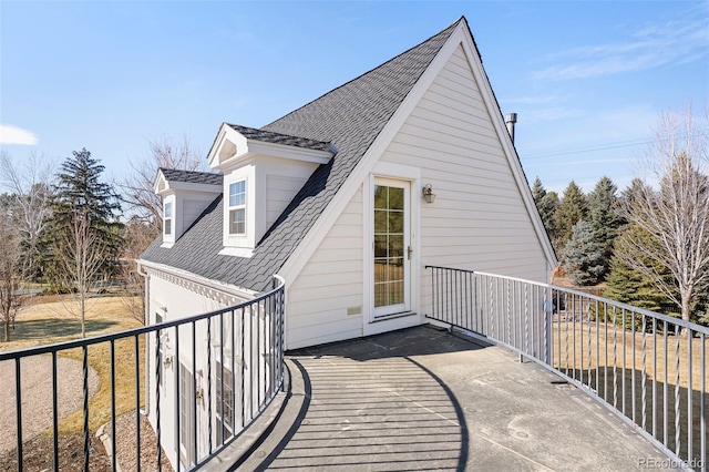 exterior space featuring roof with shingles