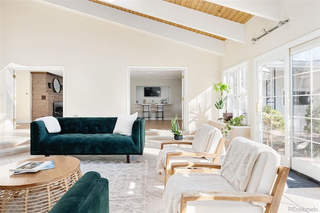 tiled living area featuring beamed ceiling, a large fireplace, high vaulted ceiling, and wooden ceiling