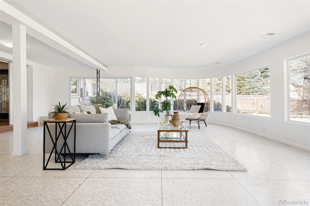 living area featuring visible vents, speckled floor, and baseboards