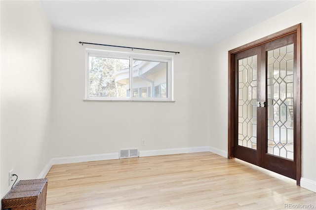 entryway featuring light wood-style flooring, french doors, visible vents, and baseboards