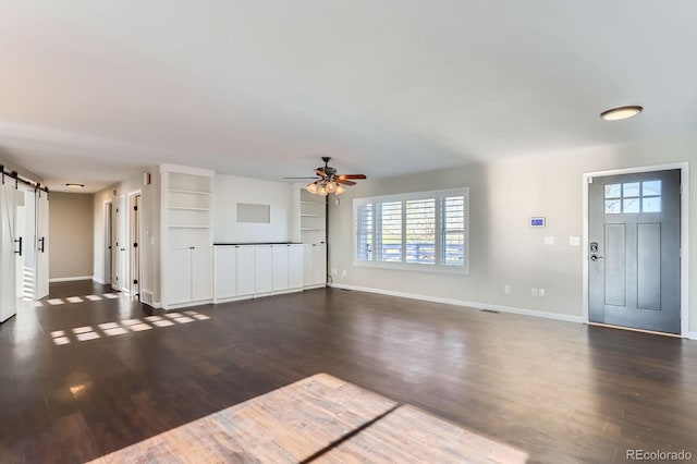 31142 County Road 18, Keenesburg, CO 80643 - unfurnished living room featuring a ceiling fan, a barn door, baseboards, and a healthy amount of sunlight