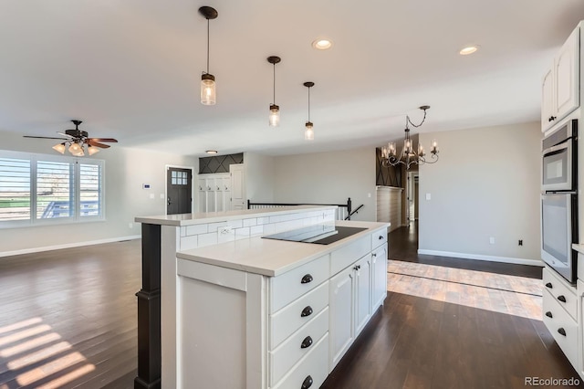 31142 County Road 18, Keenesburg, CO 80643 - kitchen featuring a center island, black electric stovetop, baseboards, and dark wood finished floors