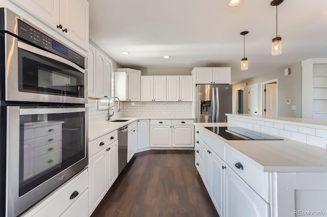 31142 County Road 18, Keenesburg, CO 80643 - kitchen featuring a sink, white cabinetry, decorative backsplash, a kitchen island, and appliances with stainless steel finishes