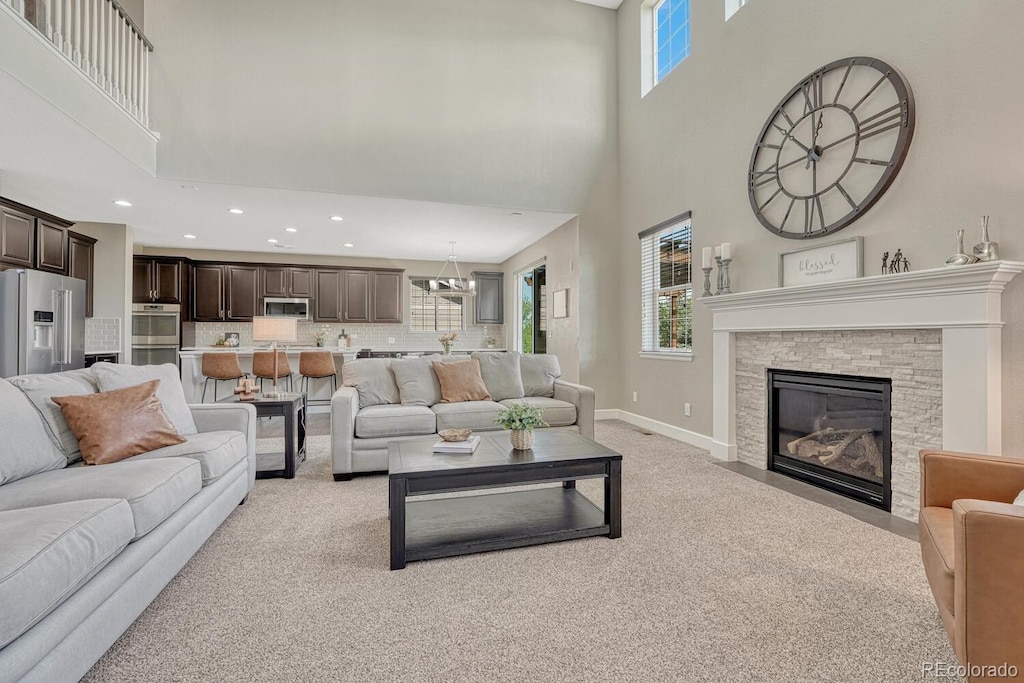 6738 Esmeralda Dr, Castle Rock, CO 80108 - living area with a high ceiling, light carpet, recessed lighting, baseboards, and a stone fireplace