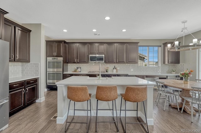6738 Esmeralda Dr, Castle Rock, CO 80108 - kitchen featuring stainless steel appliances, decorative backsplash, light countertops, light wood-style flooring, and recessed lighting