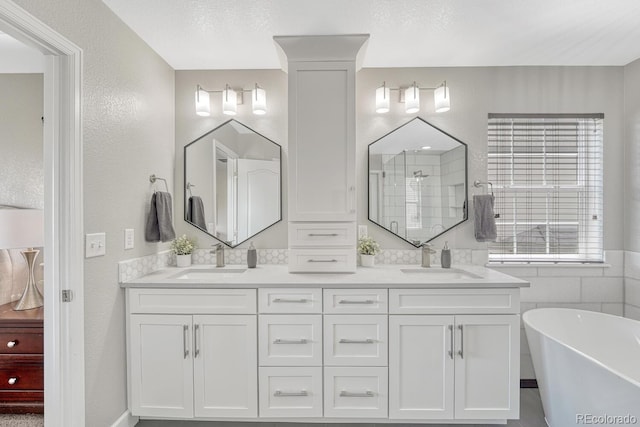 6738 Esmeralda Dr, Castle Rock, CO 80108 - bathroom featuring double vanity, a soaking tub, tiled shower, and a textured wall