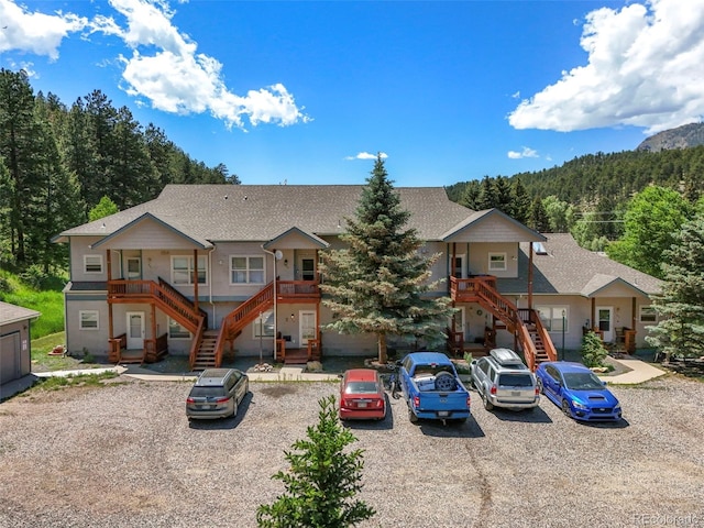 5720 County Road 64 # A102, Bailey, CO 80421 - view of front of home with stairway, a wooded view, and roof with shingles