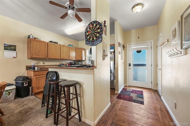 5720 County Road 64 # A102, Bailey, CO 80421 - kitchen featuring dark wood-type flooring, a ceiling fan, a kitchen breakfast bar, and dark countertops