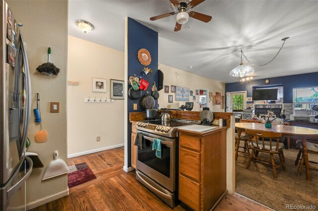 5720 County Road 64 # A102, Bailey, CO 80421 - kitchen with stainless steel appliances, wood finished floors, a chandelier, and a ceiling fan