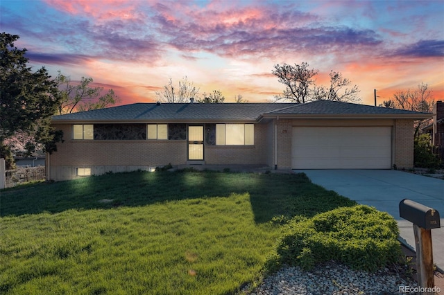 772 Urban Ct, Lakewood, CO 80401 - view of front of home featuring a lawn, an attached garage, driveway, and brick siding