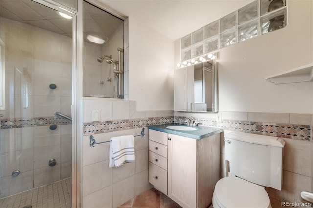 772 Urban Ct, Lakewood, CO 80401 - full bath with tile walls, a shower stall, vanity, tile patterned floors, and toilet