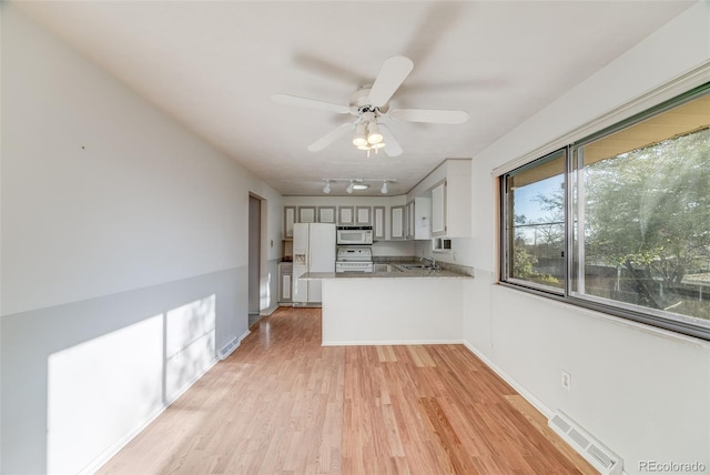772 Urban Ct, Lakewood, CO 80401 - kitchen with light wood finished floors, white appliances, a peninsula, a ceiling fan, and visible vents