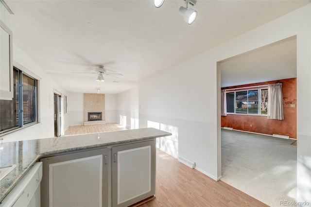 772 Urban Ct, Lakewood, CO 80401 - kitchen with light stone countertops, a ceiling fan, open floor plan, a peninsula, and visible vents