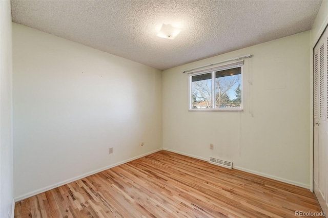 772 Urban Ct, Lakewood, CO 80401 - unfurnished bedroom with visible vents, a closet, baseboards, light wood-type flooring, and a textured ceiling