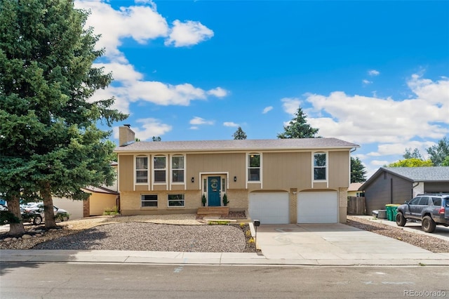4451 Ranch Cir, Colorado Springs, CO 80918 - bi-level home with driveway, a chimney, and a garage