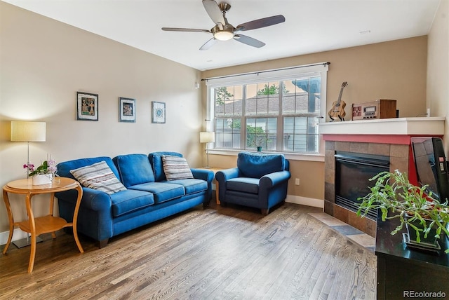 1160 S Sherman St, Denver, CO 80210 - living area with wood finished floors, a ceiling fan, a tiled fireplace, and baseboards
