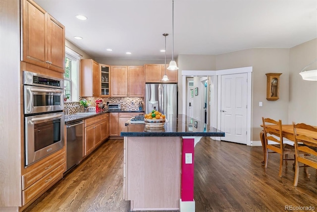 1160 S Sherman St, Denver, CO 80210 - kitchen featuring stainless steel appliances, dark countertops, dark wood-style floors, a center island, and glass insert cabinets