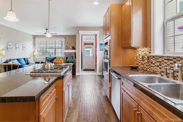 1160 S Sherman St, Denver, CO 80210 - kitchen featuring open floor plan, dark wood-type flooring, dark countertops, appliances with stainless steel finishes, and brown cabinetry