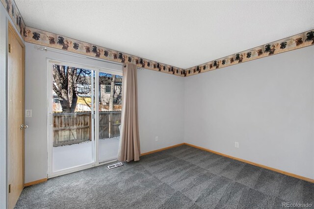 carpeted empty room with a textured ceiling