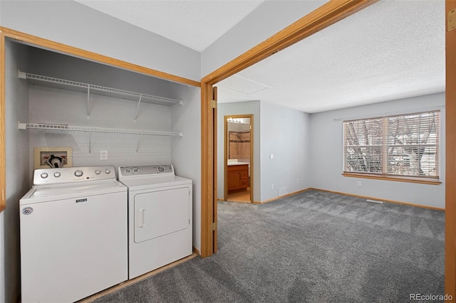 laundry room with carpet flooring, washing machine and clothes dryer, and a textured ceiling