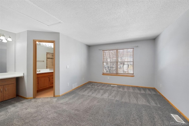 unfurnished bedroom featuring light carpet, connected bathroom, and a textured ceiling