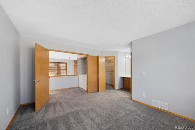 unfurnished room with carpet, washer and dryer, and a textured ceiling