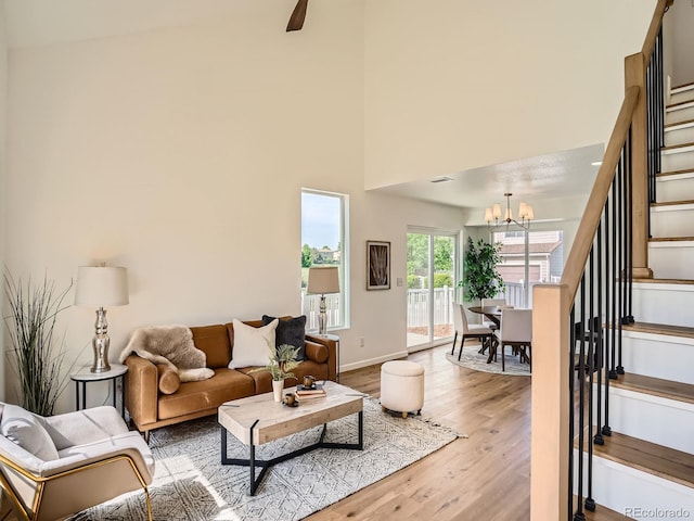 21472 E 46th Ave, Denver, CO 80249 - living area with stairway, wood finished floors, a chandelier, baseboards, and ceiling fan