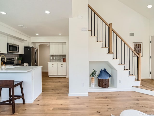 21472 E 46th Ave, Denver, CO 80249 - staircase featuring wood finished floors, recessed lighting, arched walkways, and ornamental molding