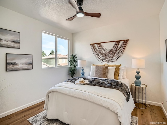 21472 E 46th Ave, Denver, CO 80249 - bedroom with baseboards, wood finished floors, a ceiling fan, and a textured ceiling