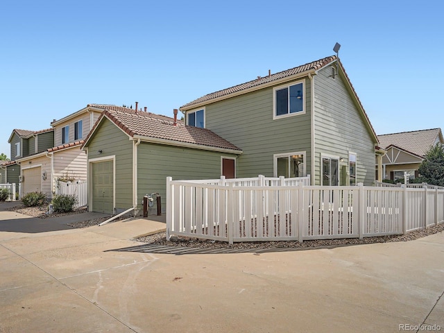 21472 E 46th Ave, Denver, CO 80249 - rear view of property featuring an attached garage, driveway, and a tiled roof