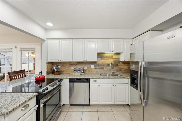 2121 Carmel Dr, Colorado Springs, CO 80910 - kitchen featuring appliances with stainless steel finishes, a sink, white cabinetry, and light stone counters