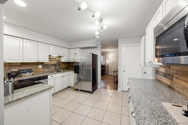 2121 Carmel Dr, Colorado Springs, CO 80910 - kitchen with white cabinetry, light tile patterned flooring, a sink, stainless steel appliances, and backsplash