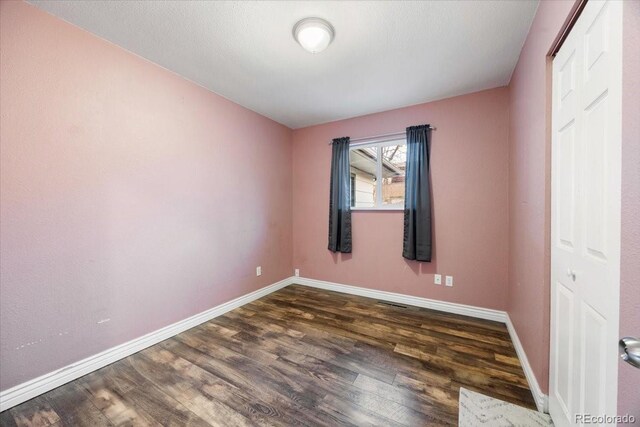 2121 Carmel Dr, Colorado Springs, CO 80910 - unfurnished room featuring baseboards and dark wood-style floors