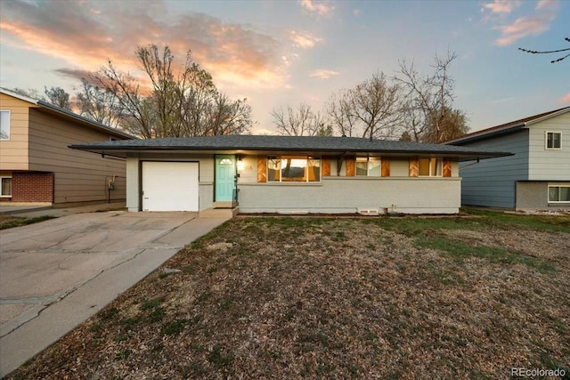 2121 Carmel Dr, Colorado Springs, CO 80910 - tri-level home featuring an attached garage, driveway, a front yard, and brick siding